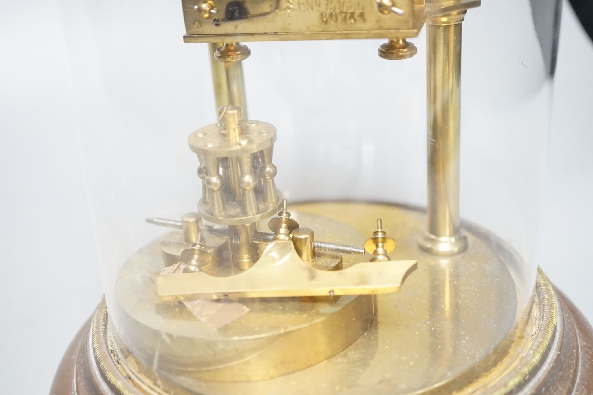 An early 20th century month going mantel timepiece, with a silk suspension, under a glass dome 29cm